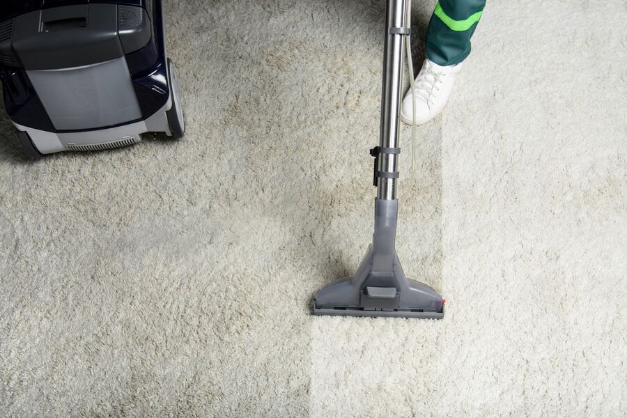 Professional vacuum cleaning light carpet in a home interior